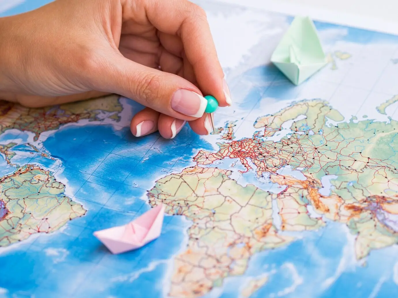 Eine Hand platziert einen Pin auf einer Karte.